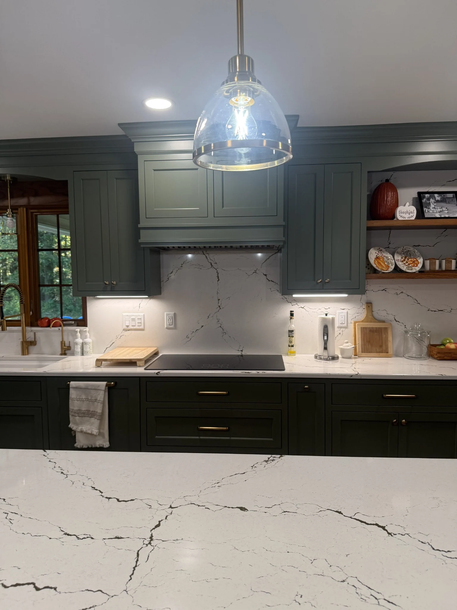 Painted cabinet fronts, an integrated hood, and a veined backsplash