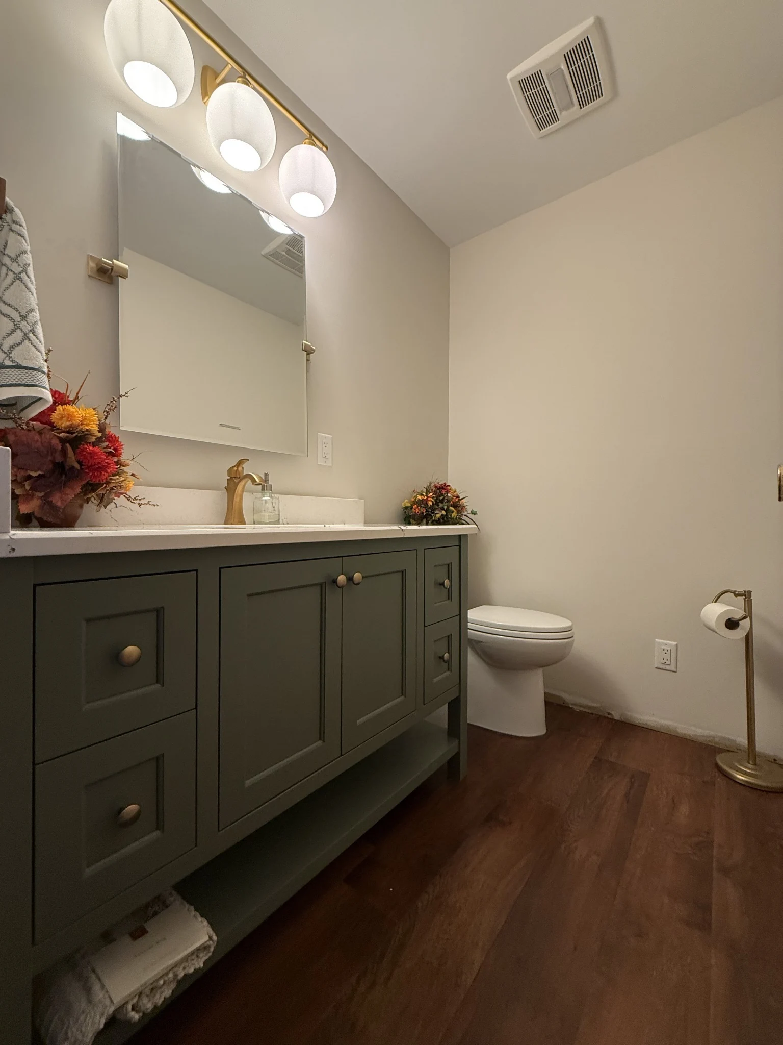 Green vanity doors, drawers, and an open lower shelf